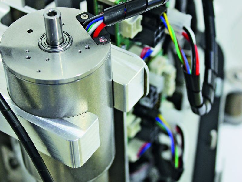 Close-up of a machined aluminium drive motor with its output shaft, cable harness and control board