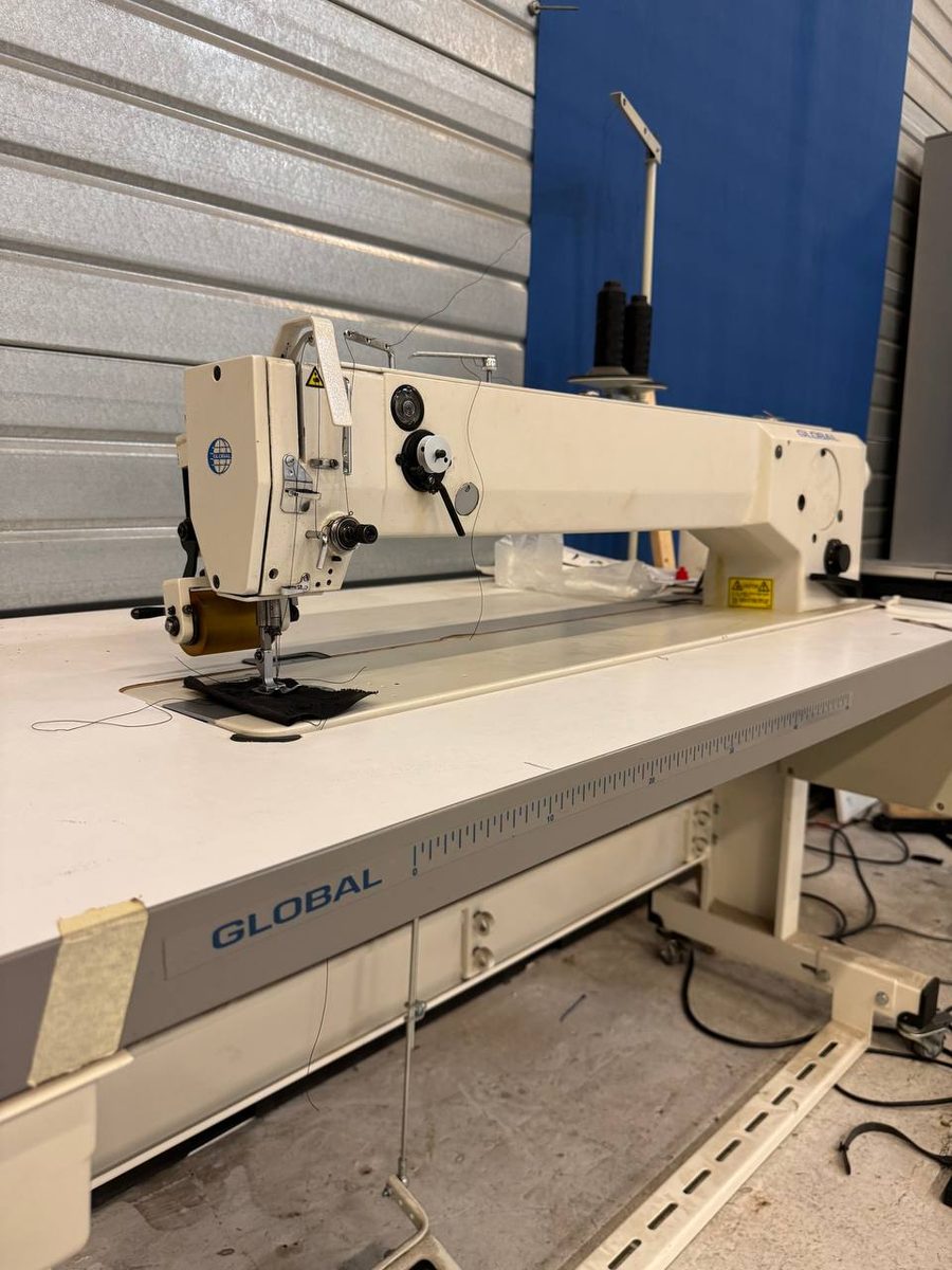 A long-arm industrial sewing machine set up for seaming heavy technical fabric
